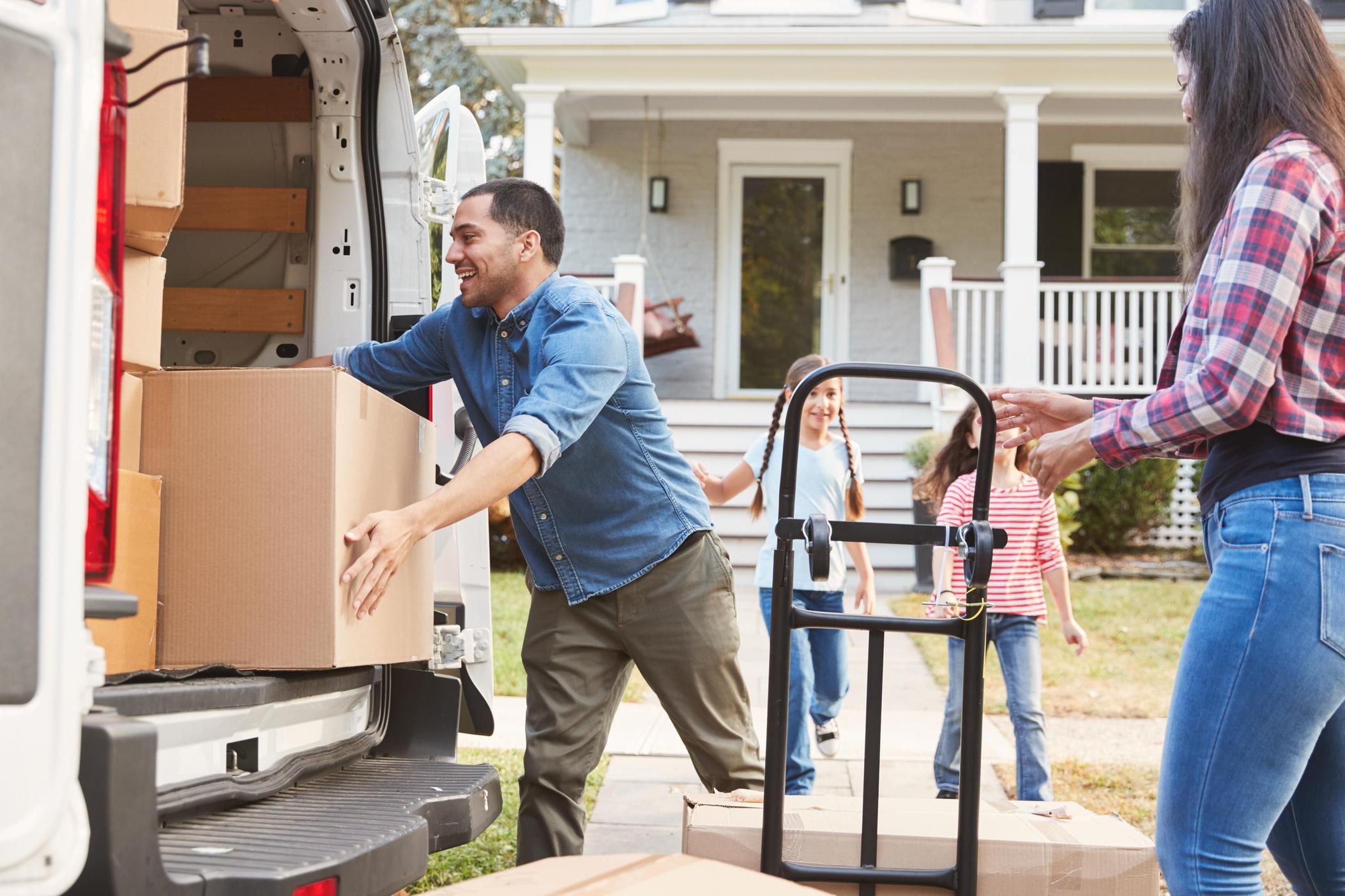 Family unloading boxes into house