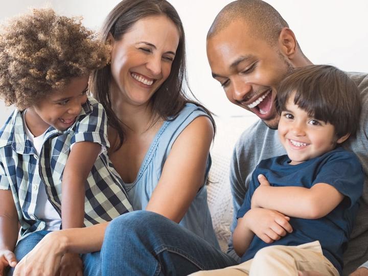 A happy family together on a couch.