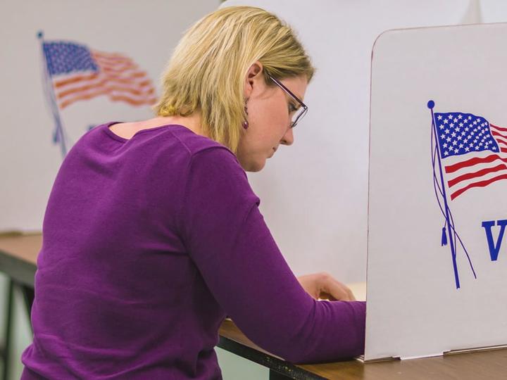 Woman at a voting booth.