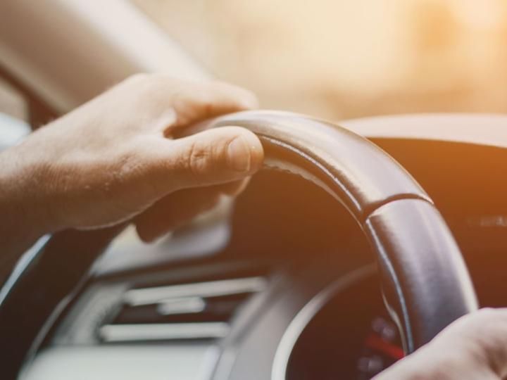 Hands on a steering wheel.