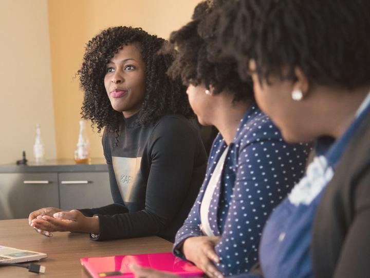 Three women meeting at a conference table.