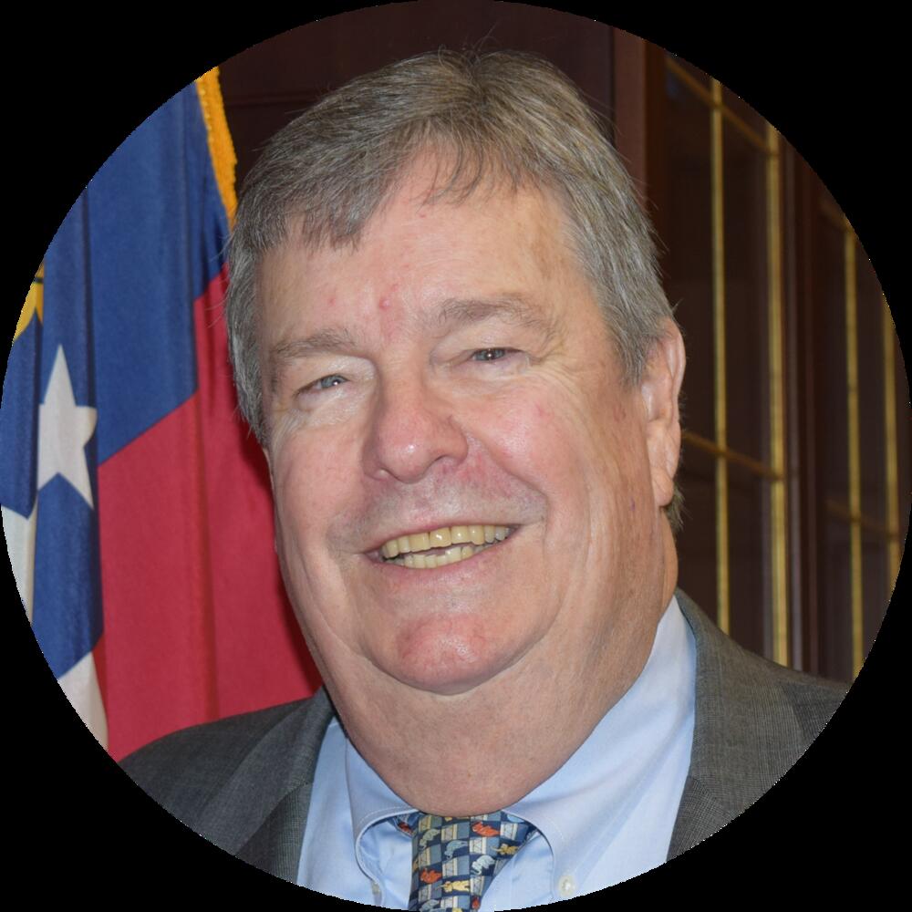 Stan Wise smiling in front of the Georgia state flag