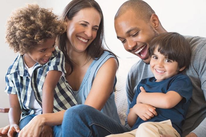 A happy family together on a couch.